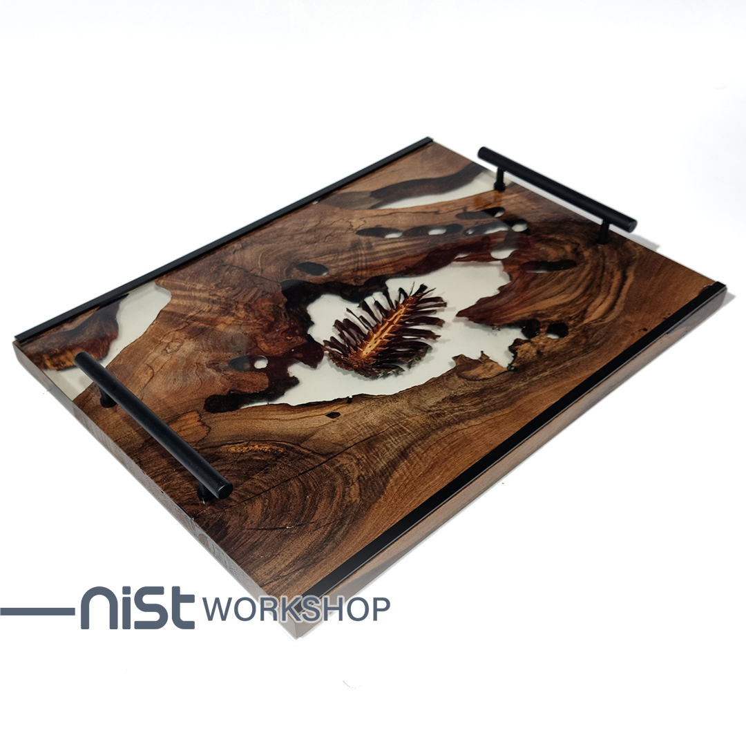 سینی چوبی دست‌ساز از چوب گردو و رزین شفاف با میوه کاج خشک شده طبیعی ، دارای دستگیره فلزی مشکی و طراحی مدرن.