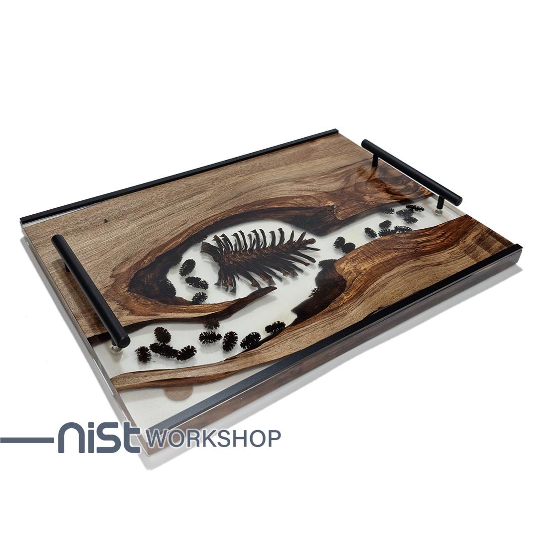 سینی چوبی دست‌ساز از چوب گردو و رزین شفاف با میوه کاج خشک شده طبیعی ، دارای دستگیره فلزی مشکی و طراحی مدرن.