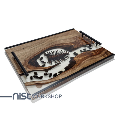 سینی چوبی دستساز از چوب گردو و رزین شفاف با میوه کاج خشک شده طبیعی ، دارای دستگیره فلزی مشکی و طراحی مدرن.